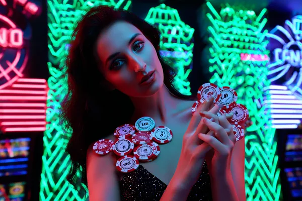 6777BET Slots — Thousands of exciting themes and jackpots A stylish woman beside vibrant slot machines displaying glowing sevens, showcasing the variety of top slots at 6777BET.