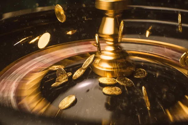 A woman smiling while playing online games on her laptop, surrounded by neon casino elements, showcasing 6777BET’s diverse game collection.