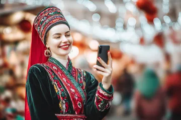 A man celebrating a winning moment on his laptop while gaming symbols float around him, capturing the excitement of 6777BET games.