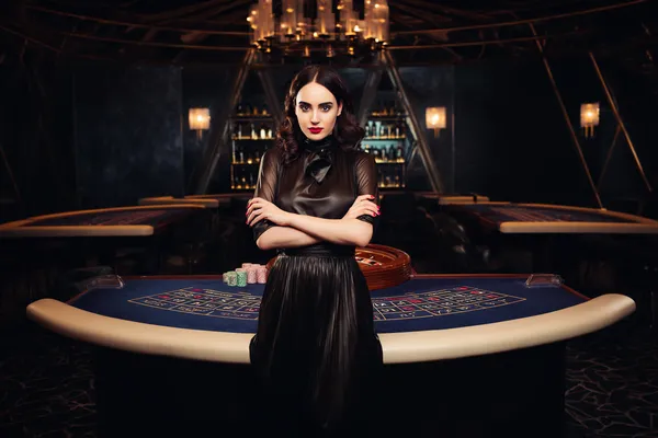 6777BET — A high-class gaming experience without limits A woman in a luxurious green gown next to an ornate roulette wheel, capturing the upscale casino mood of 6777BET.